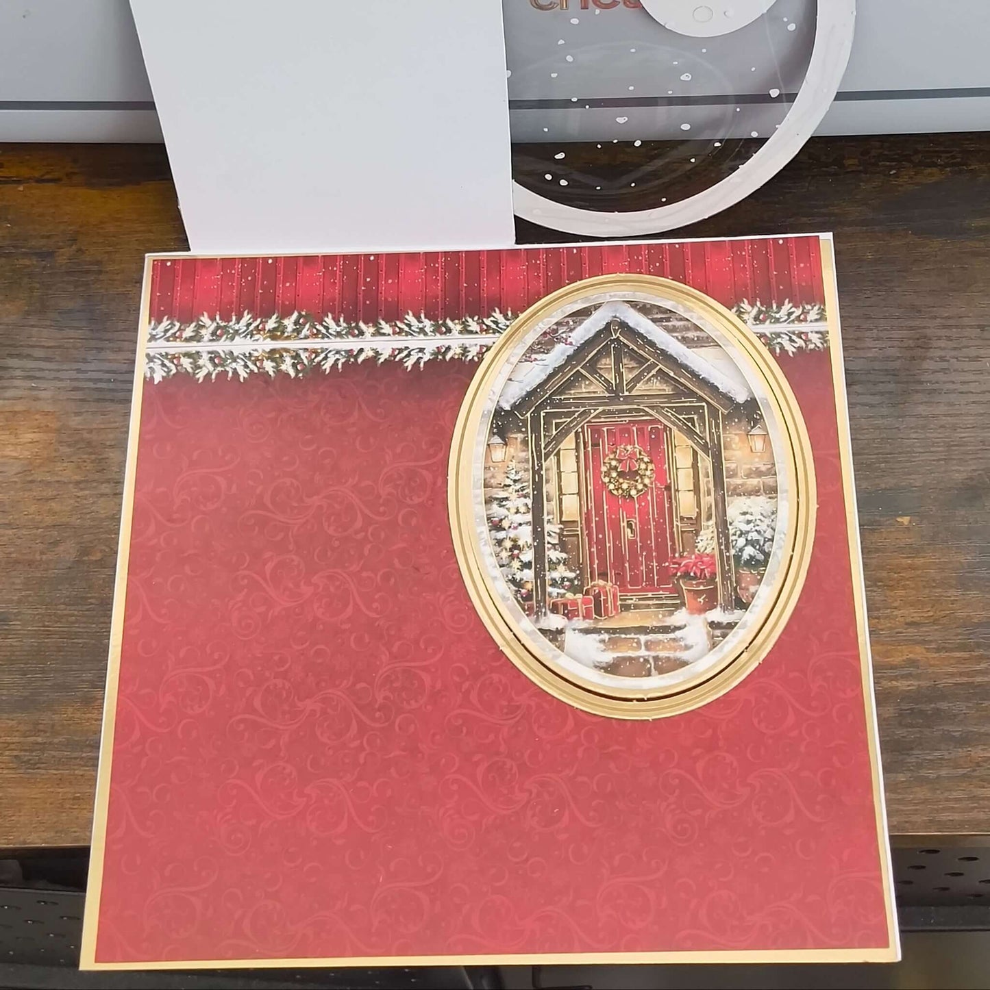 Inside view of handmade Christmas card design, showing red patterned background with oval cut-out featuring red door.