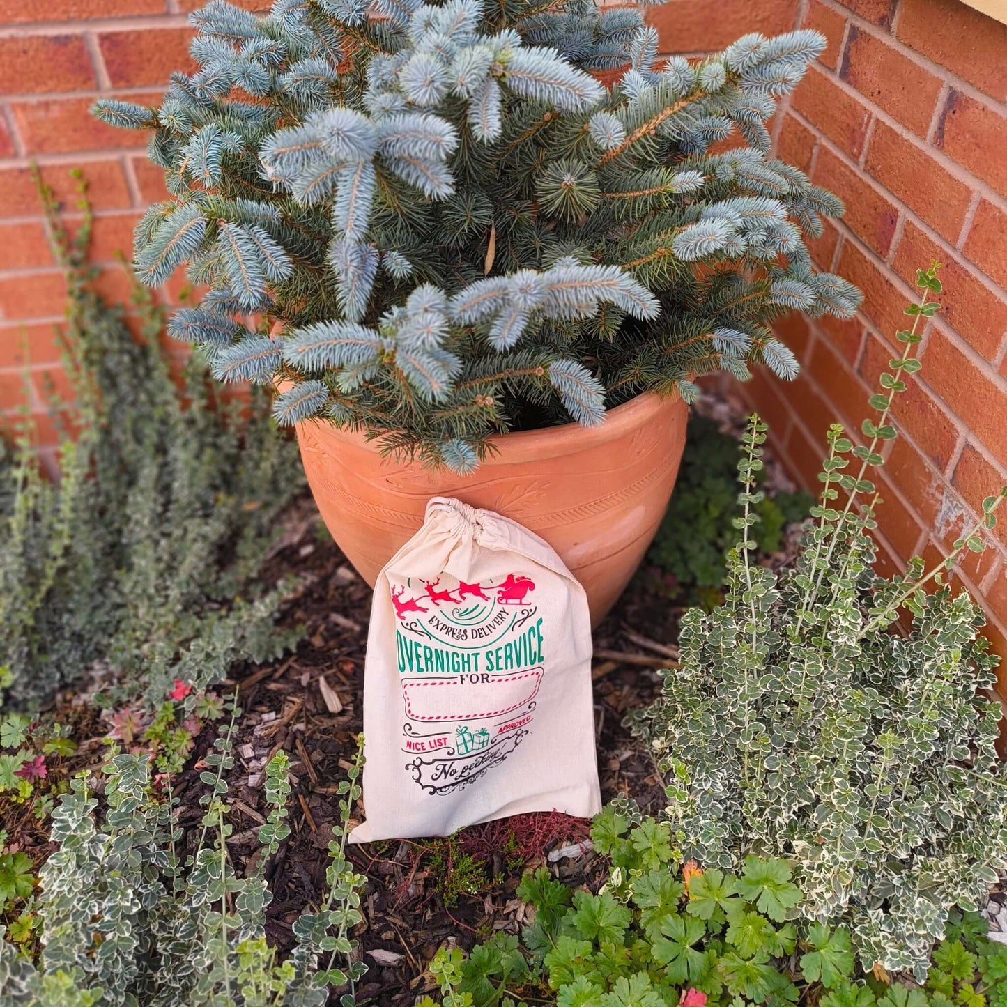 Large Christmas gift sack with express overnight delivery print placed in outdoor festive setting