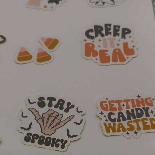 Close-up of individual Halloween stickers with phrases “Stay Spooky”, “Creep It Real”, candy corn pieces, and “Getting Candy Wasted”.
