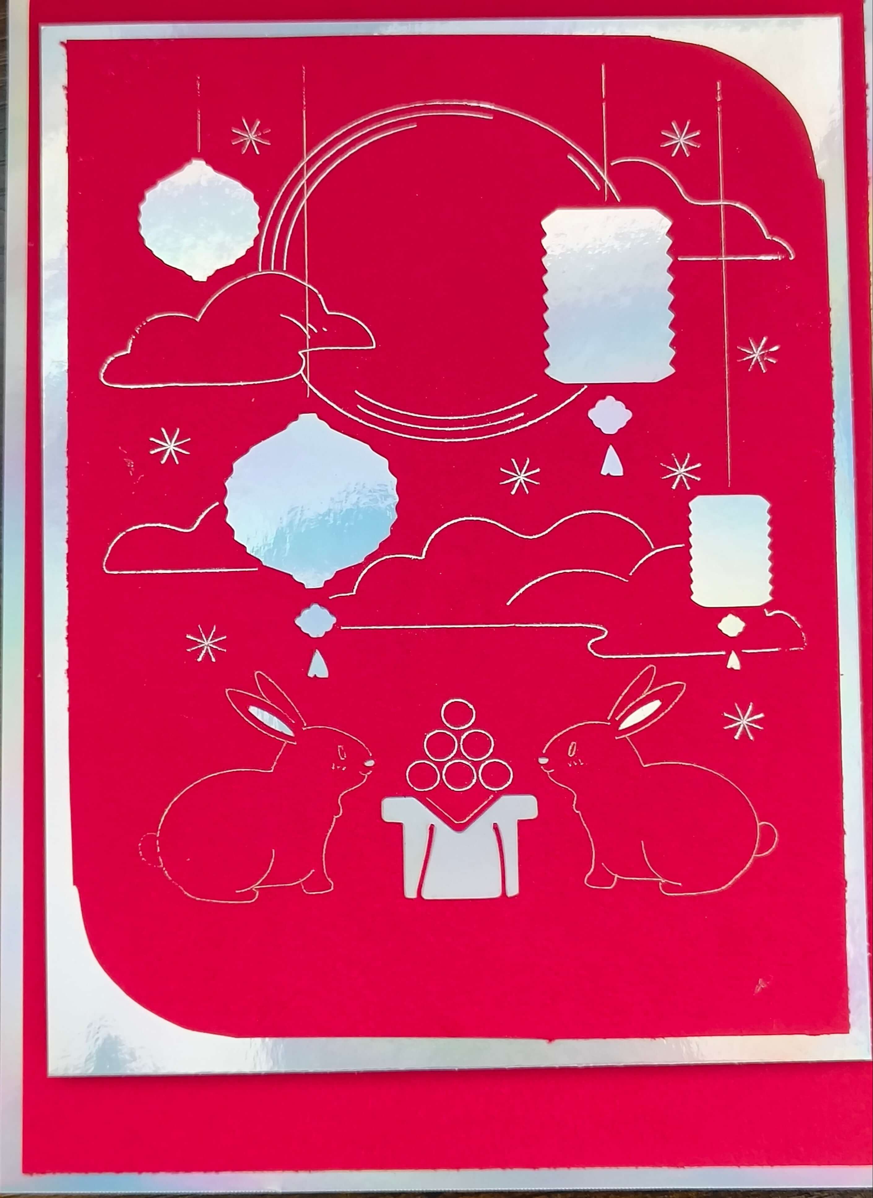Handmade red foil Mid-Autumn Festival card featuring moon rabbits, lanterns, and a celestial backdrop.