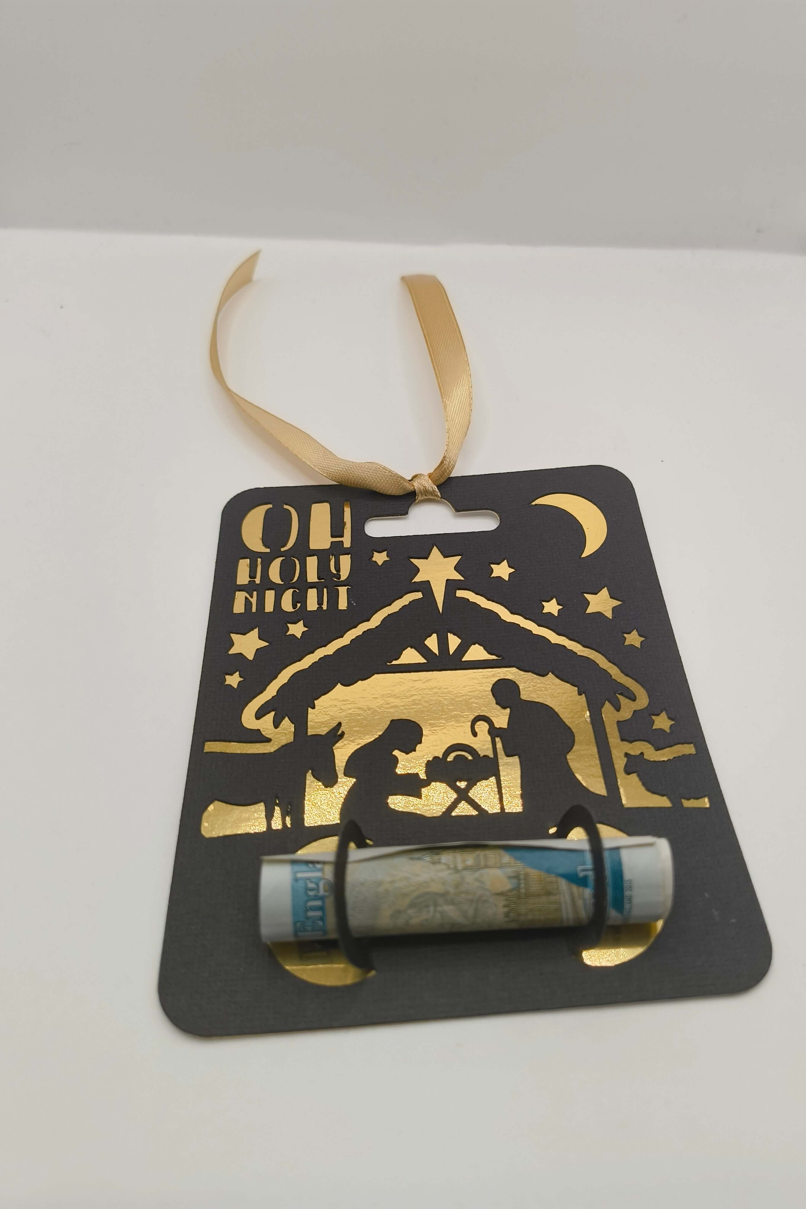 Oh Holy Night nativity money holder with gold ribbon for hanging, black card with gold design.