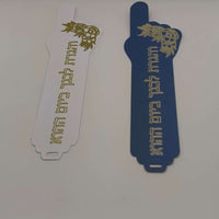 Handmade Passover bookmarks featuring Hebrew verse and intricate foil detail in white and navy blue.
