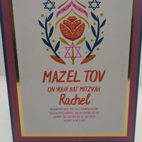 Close-up of Bat Mitzvah card with Mazel Tov message, floral Star of David design, and personalised name Rachel, finished with pink, blue, and gold foil layered cardstock.
