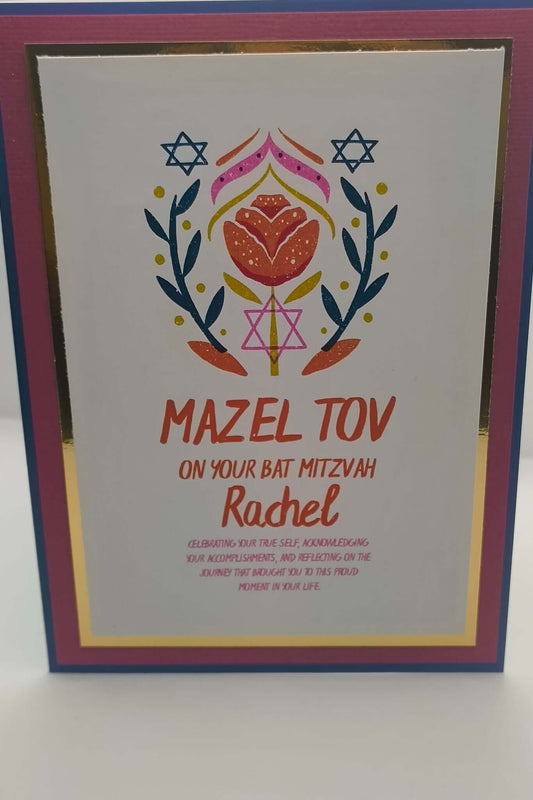 Close-up of Bat Mitzvah card with Mazel Tov message, floral Star of David design, and personalised name Rachel, finished with pink, blue, and gold foil layered cardstock.