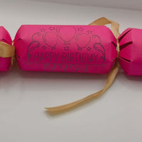 Personalised Birthday Crackers in vibrant pink with 'Happy Birthday' print and ribbon, perfect for celebrations.