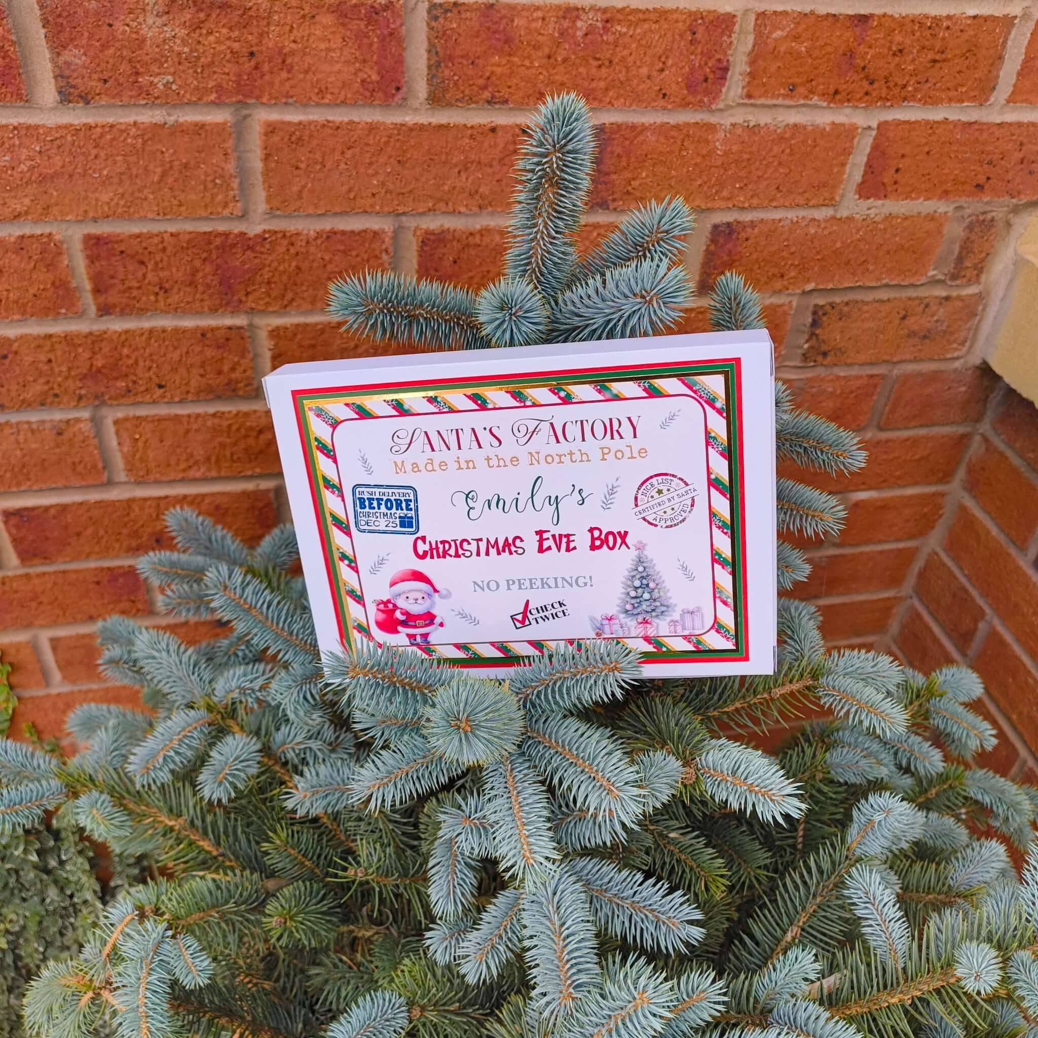 Personalised Christmas Eve box with Santa design displayed on a Christmas tree.