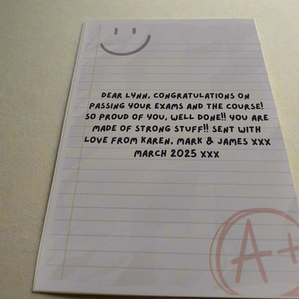 Personalised encouragement card with A+ message and custom exam congratulations text, shown from a top-side angle on a neutral background.
