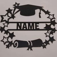 Top-down view of a handmade personalised graduation card topper featuring a black glitter mortarboard, diploma scroll, and star wreath on a white background.
