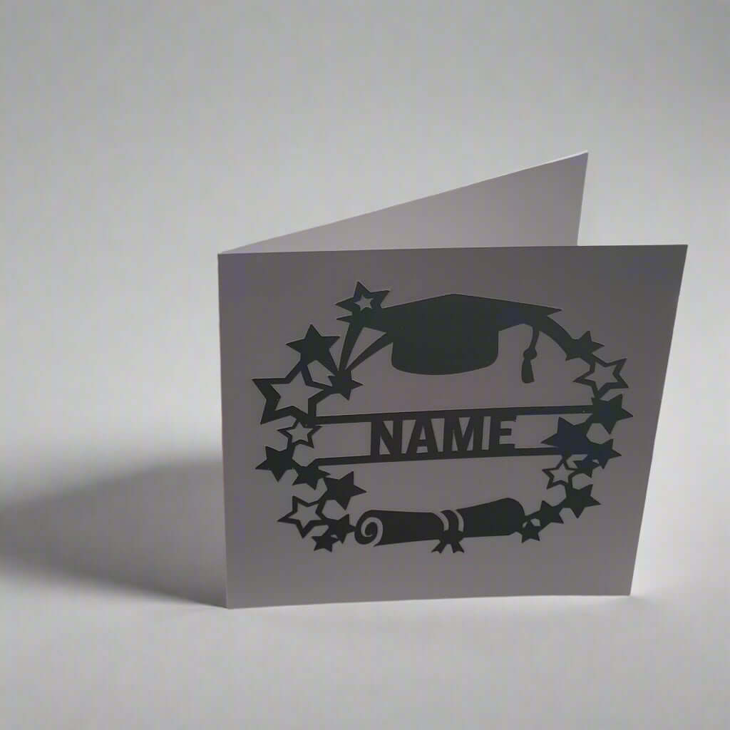 Personalised graduation card with cap, scroll, and star design, photographed from a left-side angle on a white background – handmade celebratory card.