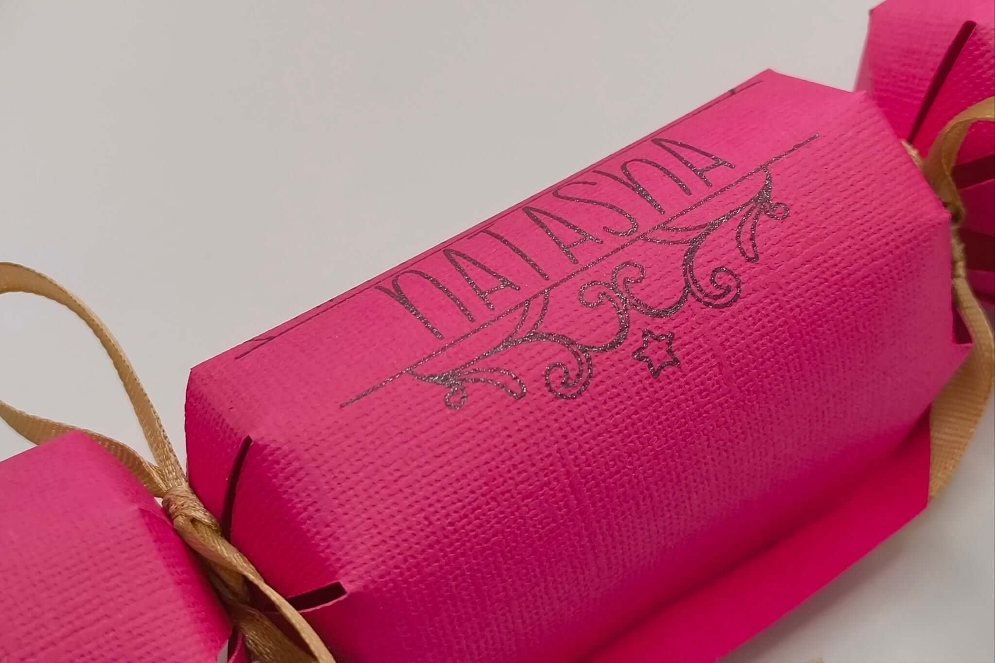 Personalised birthday crackers in vibrant pink with gold ribbon, perfect for celebrations and custom gifts.