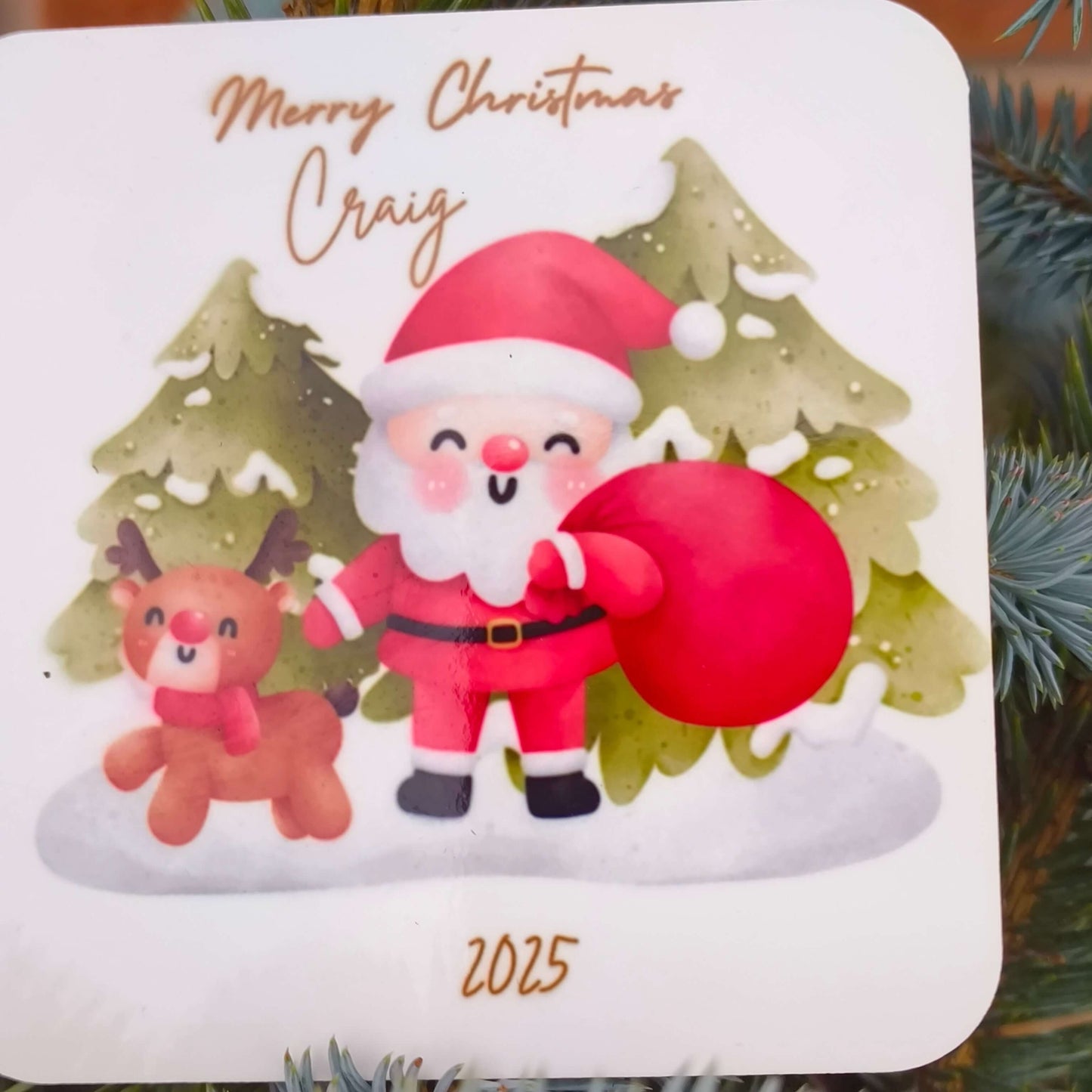 Detailed view of personalised Santa coaster with name Craig and year 2025, showing festive design with reindeer and Christmas trees.