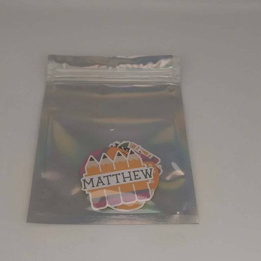 Personalised school name stickers featuring colorful pencil designs in a clear packaging for organization.