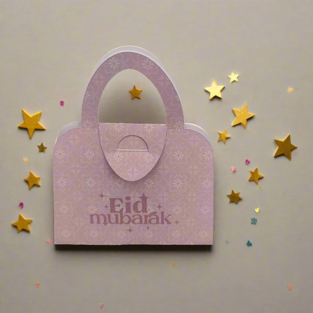 Pink floral Eid Mubarak money holder shaped like a handbag, surrounded by golden stars for festive Eid gifting.