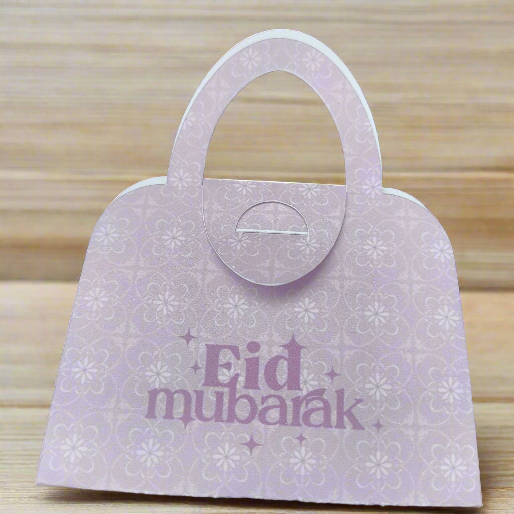 Elegant pink Eid Mubarak money holder shaped like a handbag, with floral pattern detail, perfect for gifting money during Eid celebrations.