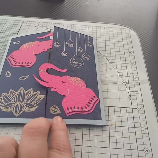 Handmade Diwali card featuring pink elephants and gold lotus design on a navy background.