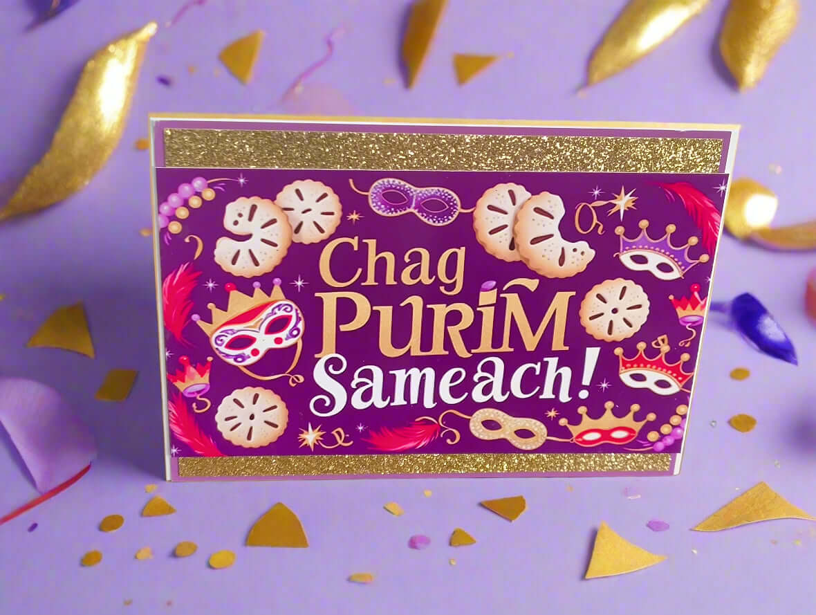 Chag Purim Sameach card with gold glitter borders, purple background, hamantaschen and mask illustrations, front angle close-up on lilac background with gold and confetti details