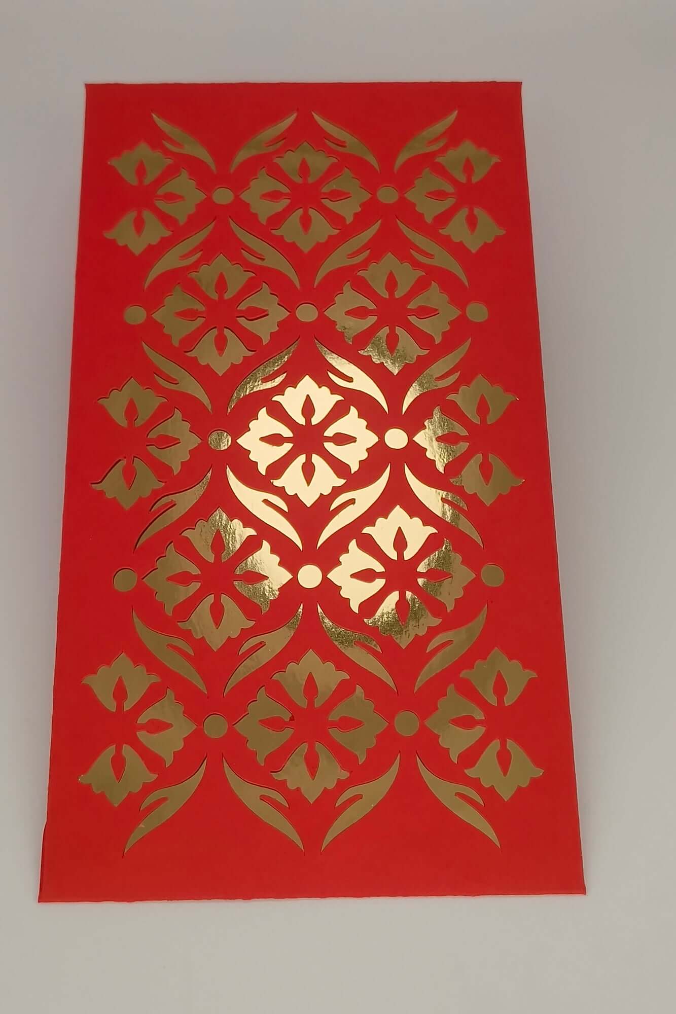 Red money envelope with intricate gold foil floral cut-out design