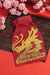 Red hessian gift bag with gold glitter dragon design and “Happy Chinese New Year” text, styled with cherry blossoms.