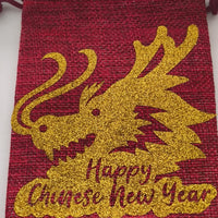 Red hessian Chinese New Year drawstring bag with sparkling gold dragon print and festive message.