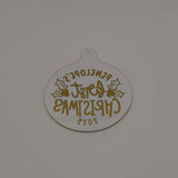 Reverse view of personalised gold and clear acrylic first Christmas bauble showing text from back.