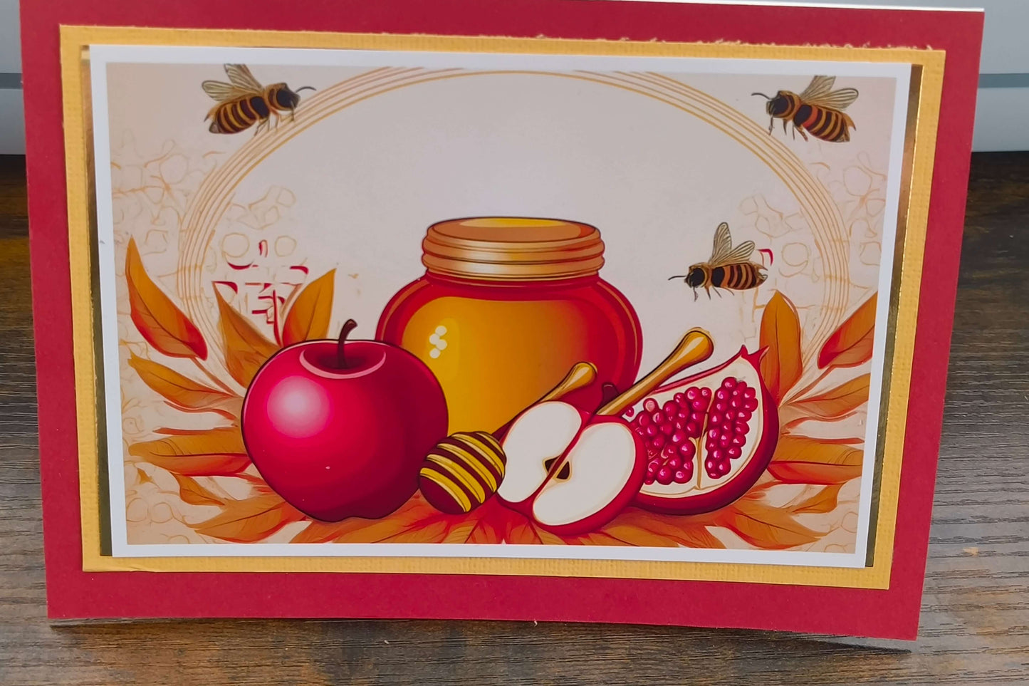 Colourful Rosh Hashanah card featuring apples, honey jar, pomegranate, and bees, celebrating the Jewish New Year.