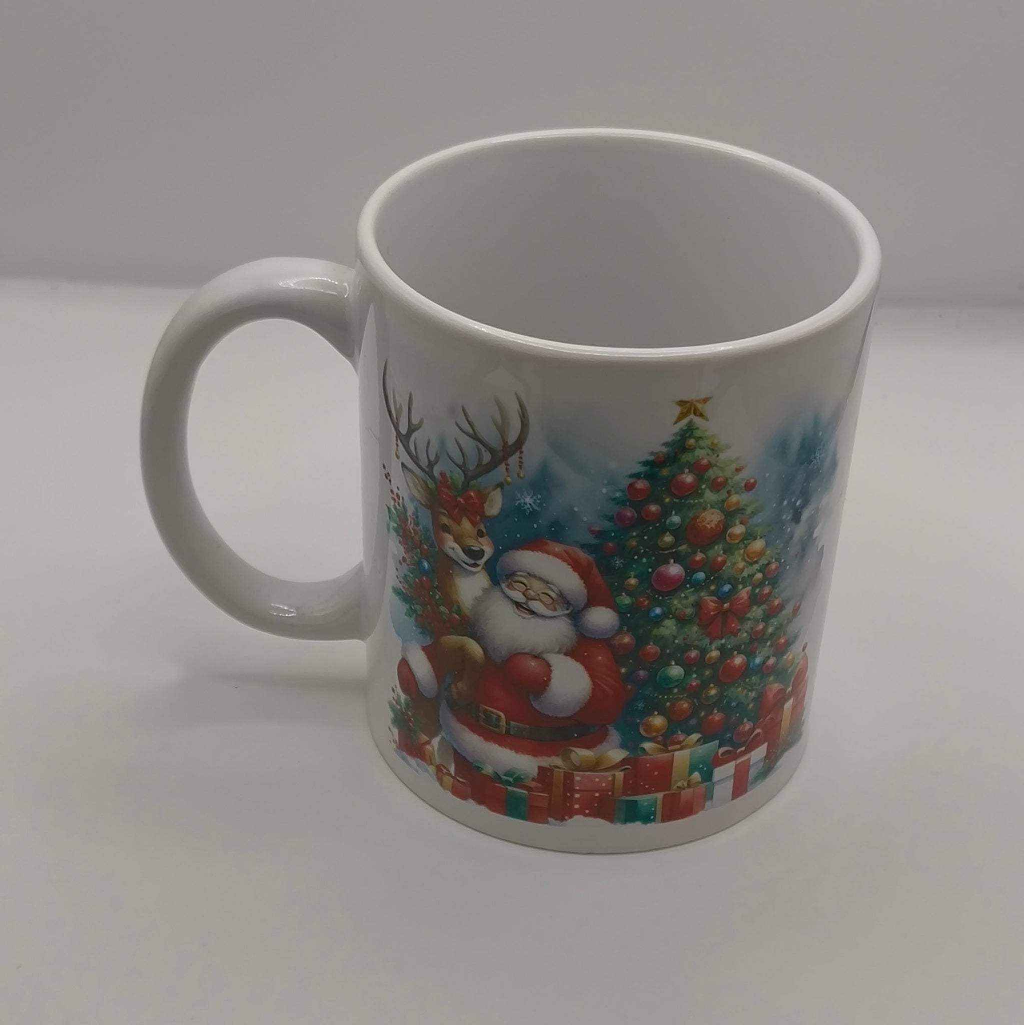 White ceramic mug with Santa Claus and Christmas tree design, displayed on plain background