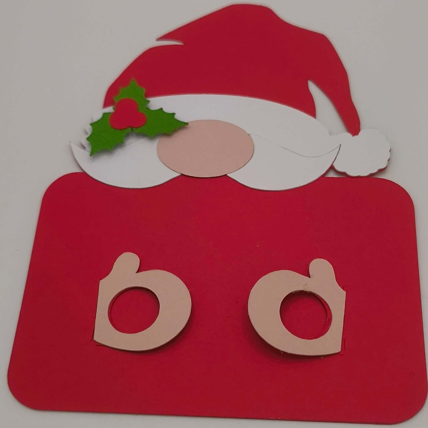 Handmade Santa money holder gift card with face and holly detail, two cut-out slots visible for holding a rolled banknote, displayed on a white background.