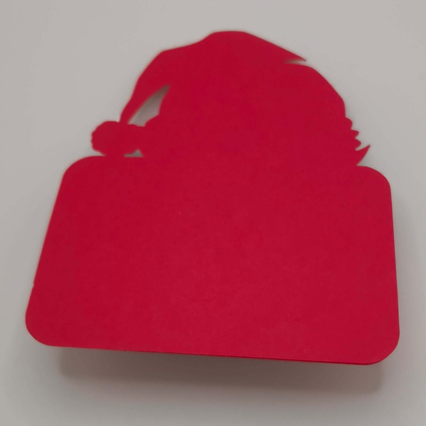 Back view of a red handmade Santa money holder card with rounded corners and Santa hat shape, shown plain without decoration.