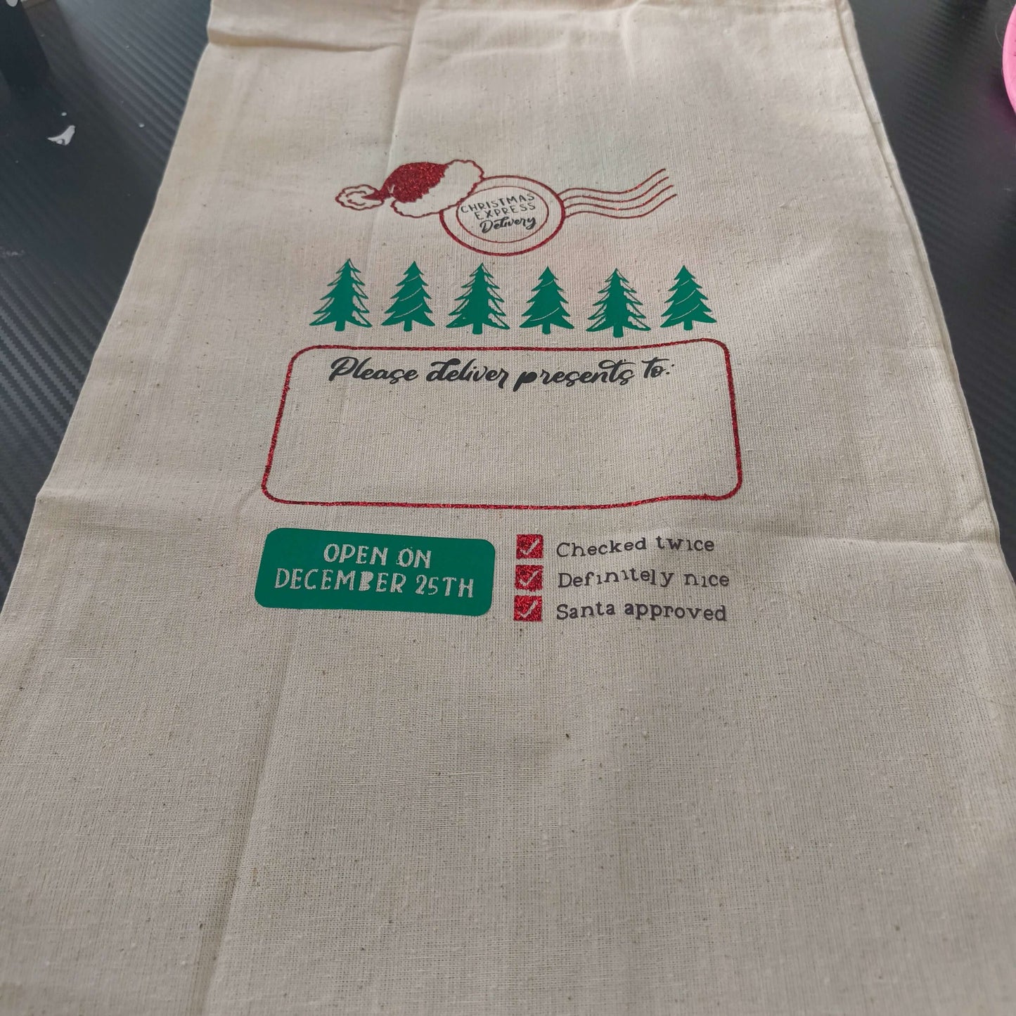 Personalised Santa sack featuring festive design with Santa hat and Christmas trees, perfect for kids' gifts.