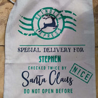 Flat lay of personalised Santa Claus sack with green and black lettering, “Special Delivery” message, and December 25 note.