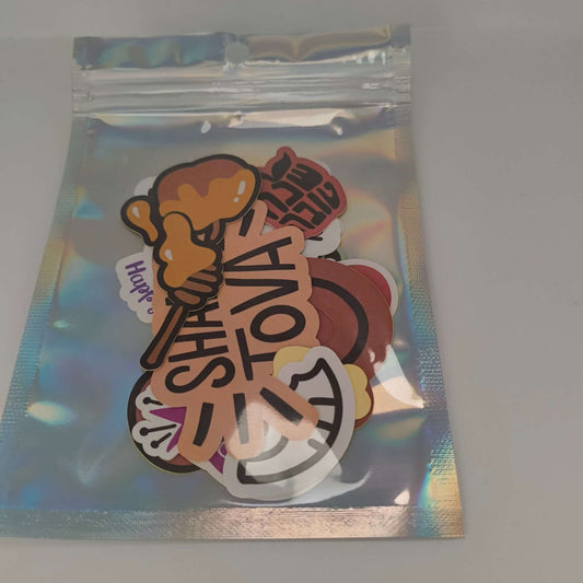 Packaged Rosh Hashanah sticker set with Shana Tova, honey, apple, and pomegranate designs inside a holographic zip bag.