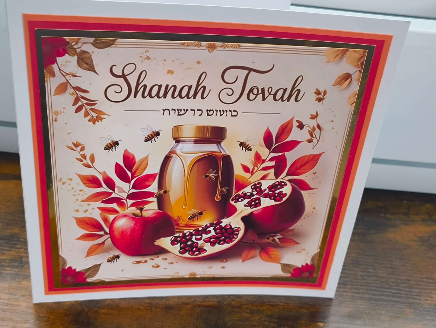 Shanah Tovah greeting card featuring apples, honey jar, and pomegranate with autumn leaves.