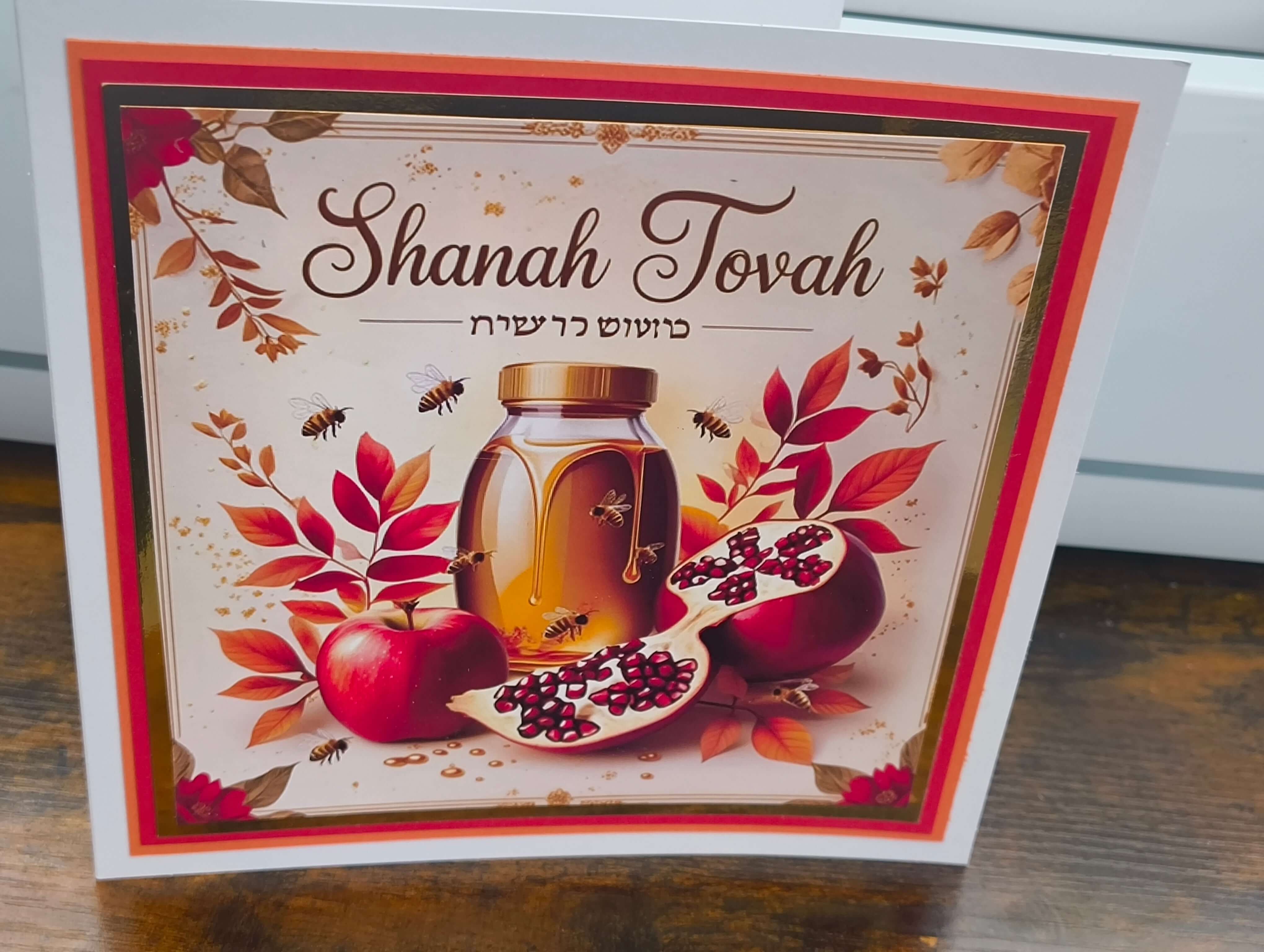 Shanah Tovah greeting card featuring apples, honey jar, and pomegranate with autumn leaves.