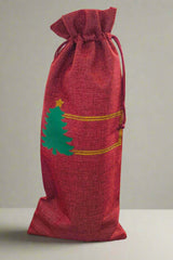 Personalised Christmas wine bottle bag in red hessian with green tree design, perfect for festive gifting.